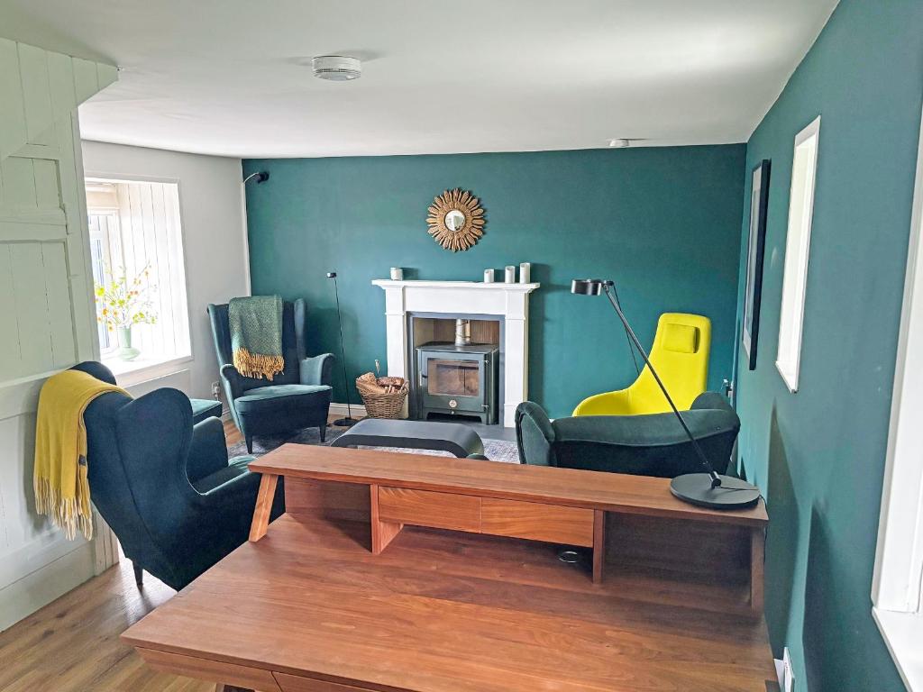 a living room with a table and chairs and a fireplace at Tigh An Dun in Luib