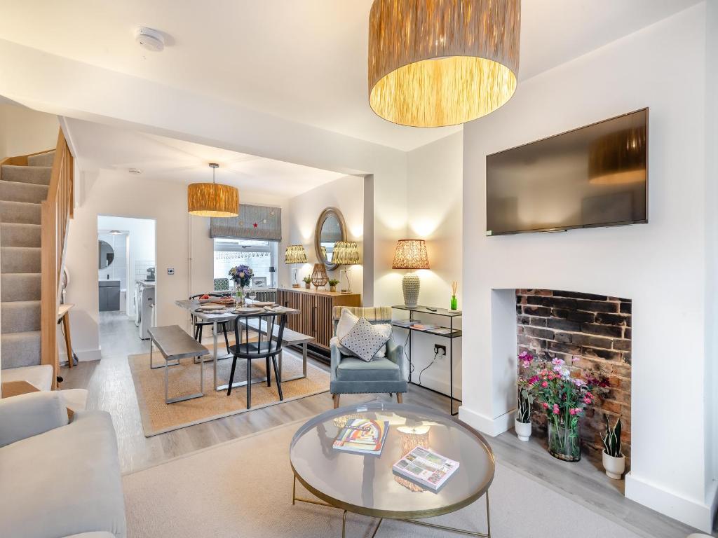 a living room with a table and a fireplace at Big Skies in Lowestoft