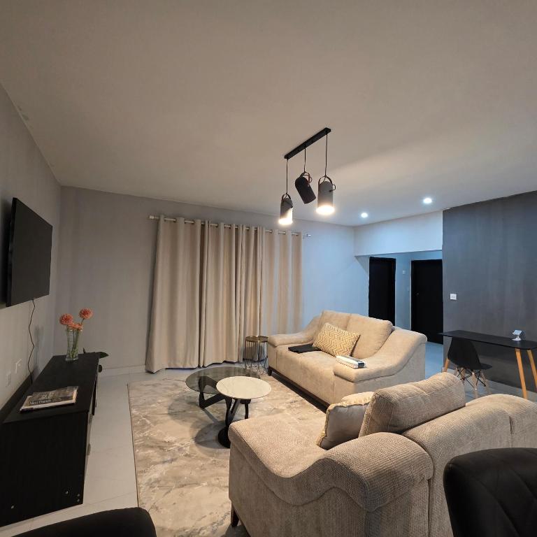 a living room with two couches and a table at Fully Furnished Apartments in Manyama, Lumwana Mine in Chanamo