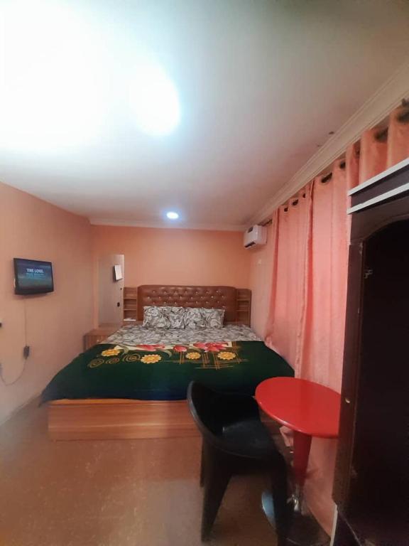 a bedroom with a bed and a red table at St Nicholas Guest Inn in Galadima