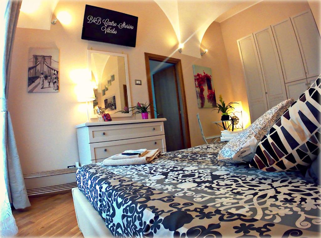 a bedroom with a bed with a black and white comforter at B&B Centro Storico Viterbo in Viterbo