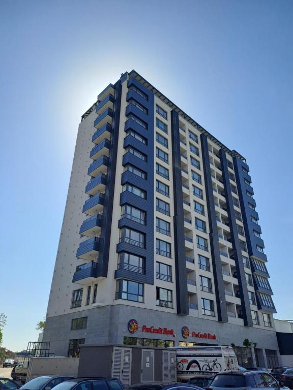 a tall building with cars parked in a parking lot at MarVi home in Ruse
