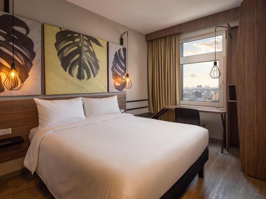 a hotel room with a large bed and a window at ibis Santa Cruz de la Sierra in Santa Cruz de la Sierra
