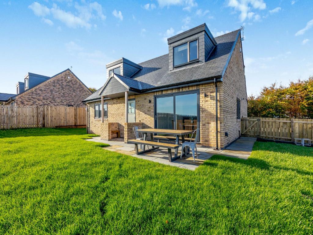 a house with a picnic table in the yard at The Bunker - Uk47763 in Bamburgh