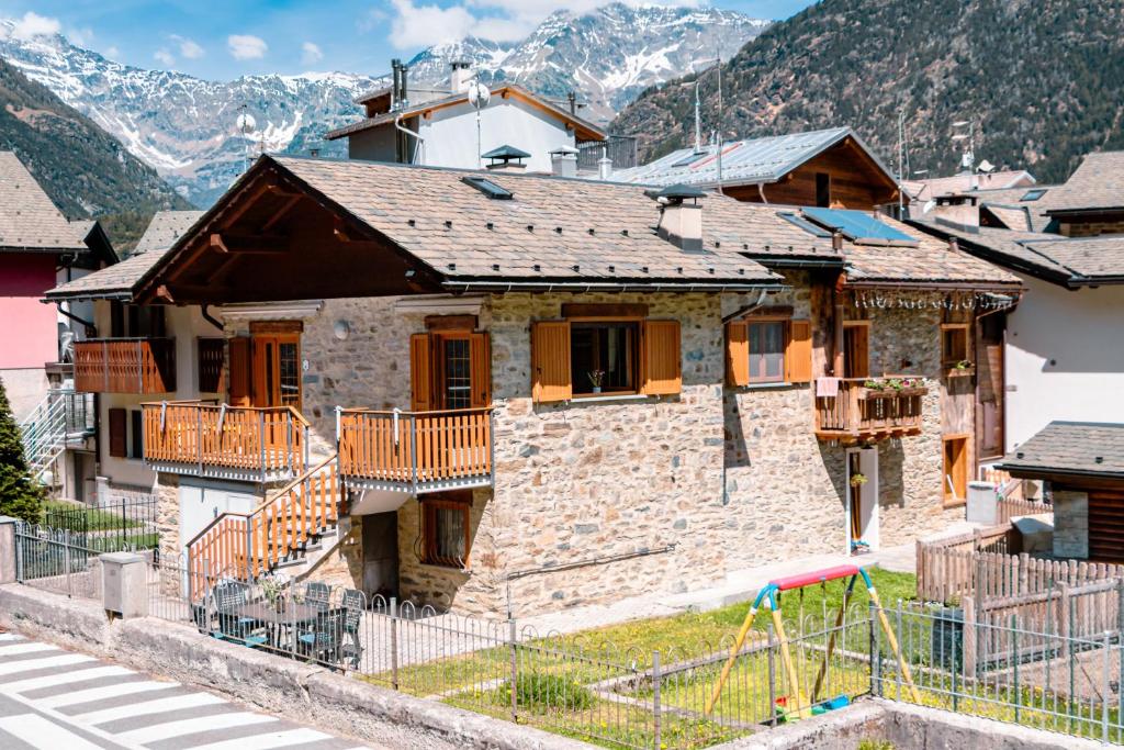 a house in a village with mountains in the background at Casa Bruna Valmalenco, Casa vacanze sopra Caspoggio in Caspoggio