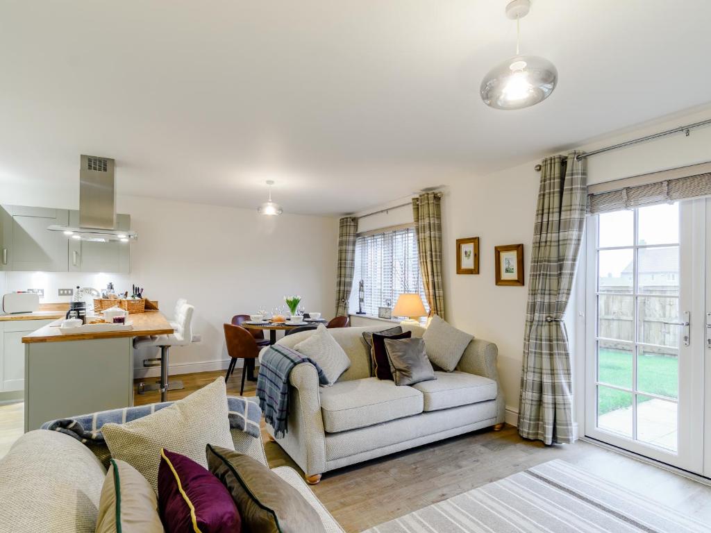 a living room with a couch and a kitchen at Popleys in Helmsley