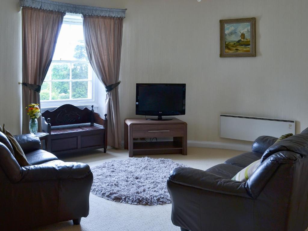 a living room with two couches and a flat screen tv at Gibson Apt- Cv11 in Liskeard