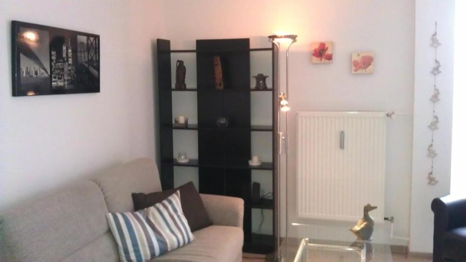 a living room with a couch and a book shelf at Apartment Kati in Ingolstadt