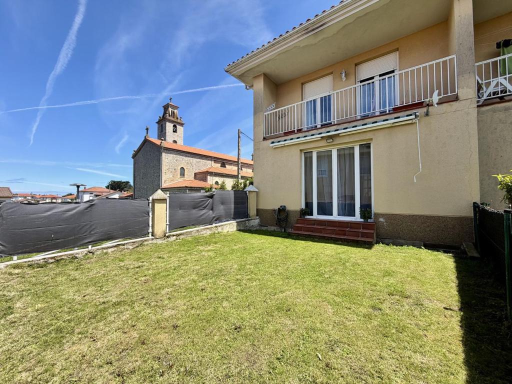 a house with a yard in front of a building at Apartamento Albamar 32802 in Pedreña