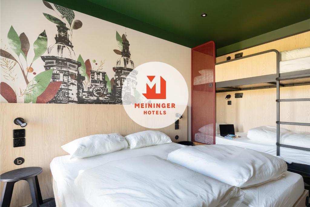 a bedroom with two beds and a sign on the wall at MEININGER Hotel Edinburgh Haymarket in Edinburgh