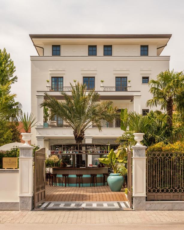 a building with a table in front of it at Villa Costanza Boutique Hotel in Forte dei Marmi