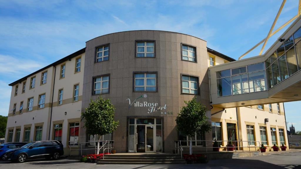 a building with cars parked in front of it at The Villa Rose Hotel & V-Spa in Ballybofey