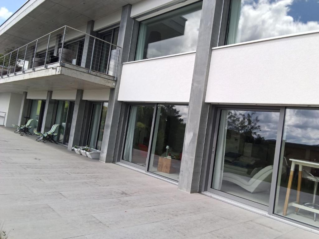a building with glass windows and a balcony at Hillfort suites in Lostorf