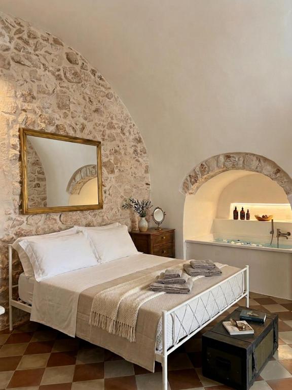a bedroom with a bed and a stone wall at La Suite di Alizeh in Ostuni
