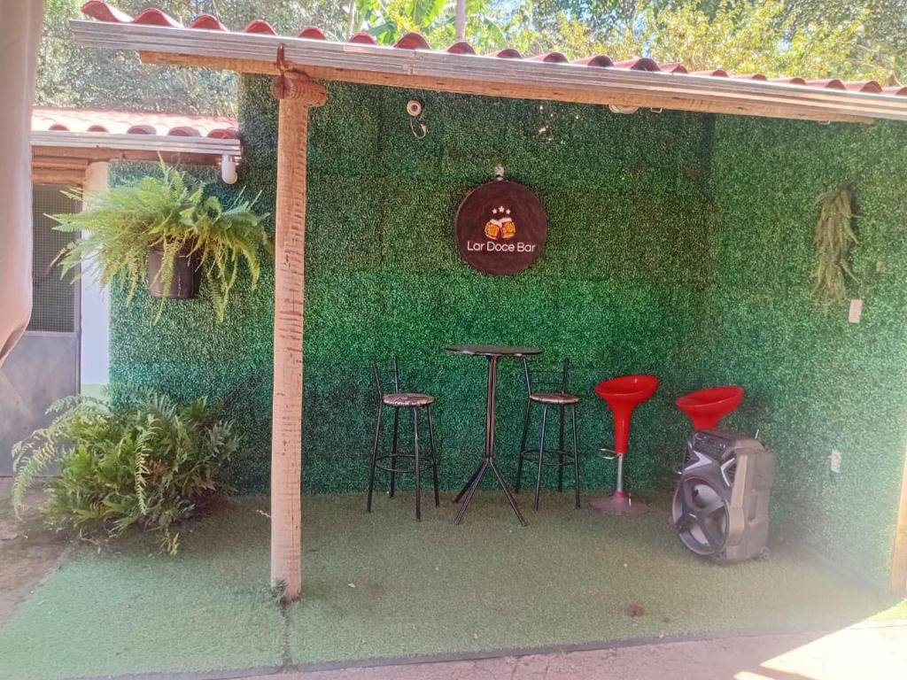 a green wall with two stools and a bar at Sitio Daniel in Mateus Leme