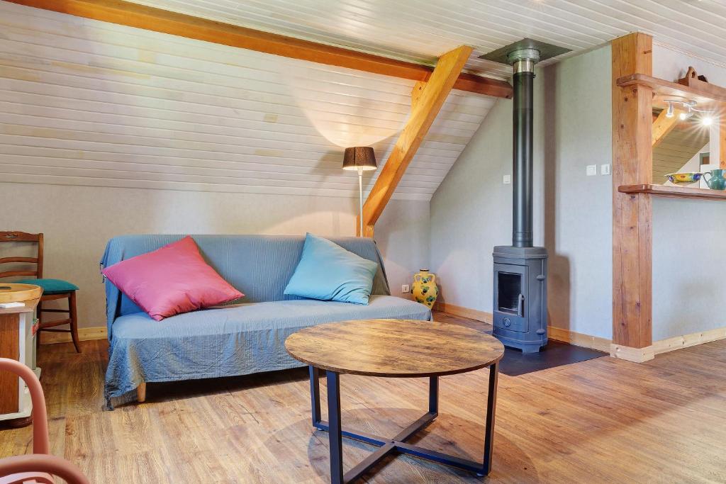a living room with a couch and a wood stove at L'Appartement des Trois Vallées in Villelongue