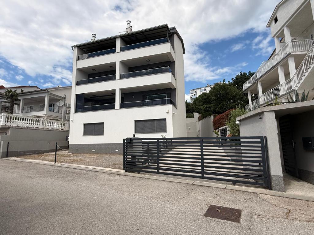 a white building with a gate in front of it at AppMishadze in Crikvenica