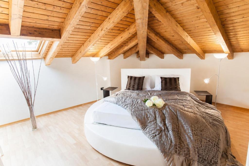 a bedroom with a large bed with a wooden ceiling at AcquaTerraFuoco - City Apartments in Como