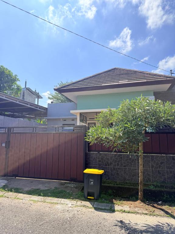 a house with a fence and a yellow trash can at Uma Pirates Lombok in Mataram