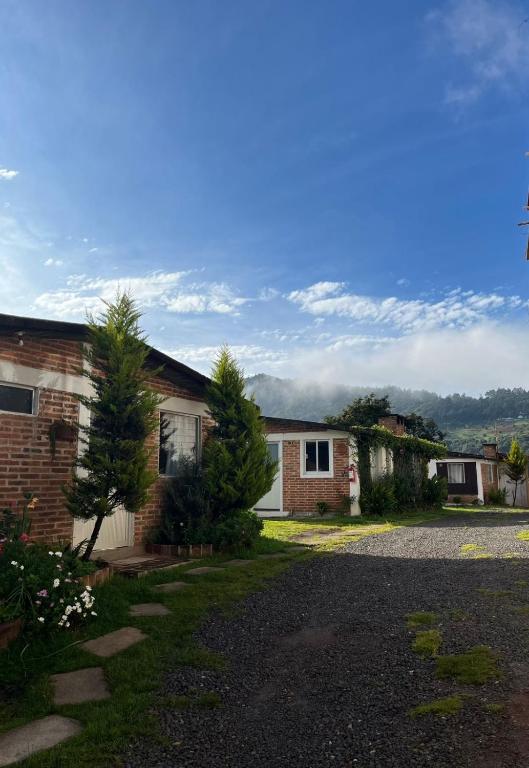 a brick house with a driveway in front of it at La Misión Cabañas Chignahuapan in Chignahuapan