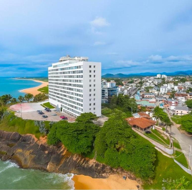an aerial view of a white building on the beach at Guarapari com elevador, reformado, Wi-Fi, TV com Smart, vista livre e estacionamento in Guarapari