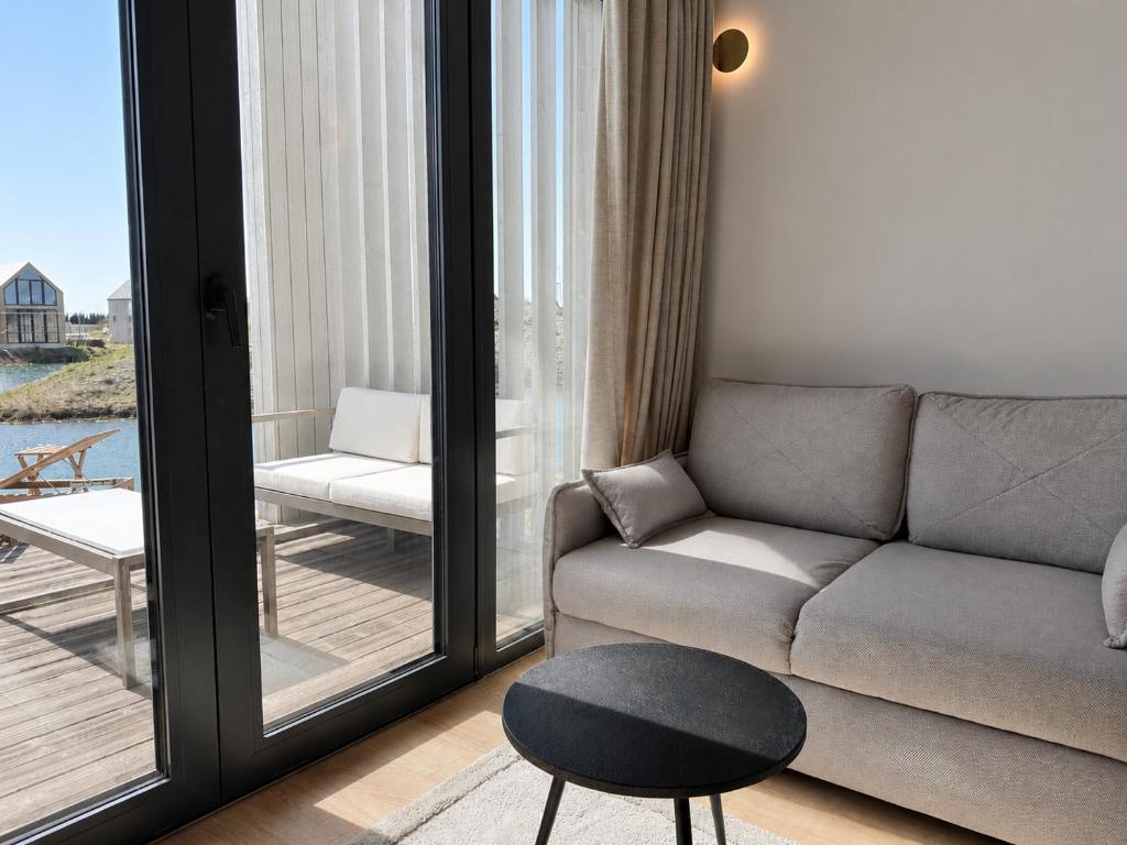 a living room with a couch and a table at Pirtelių resort - Pilkasis namelis in Kiauleikiai