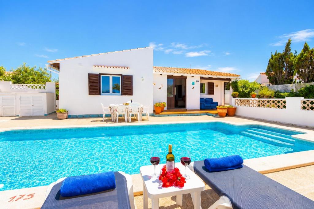 a villa with a swimming pool in front of a house at Villa Ca Nostra in Cala en Porter