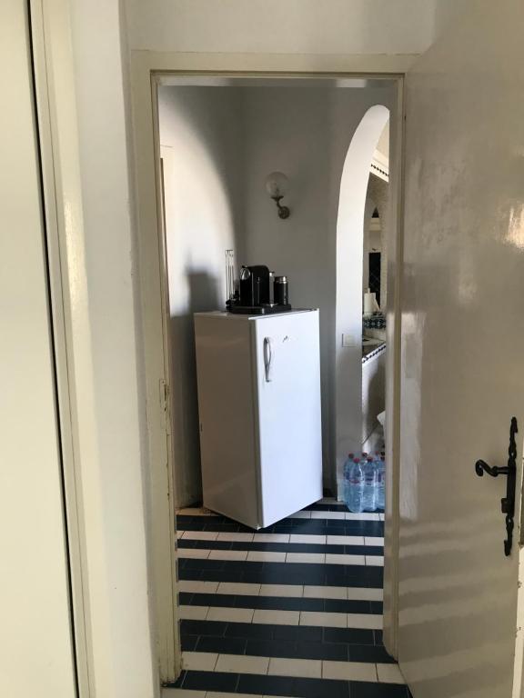 a hallway with a small refrigerator in a kitchen at Vue superbe in Port El Kantaoui
