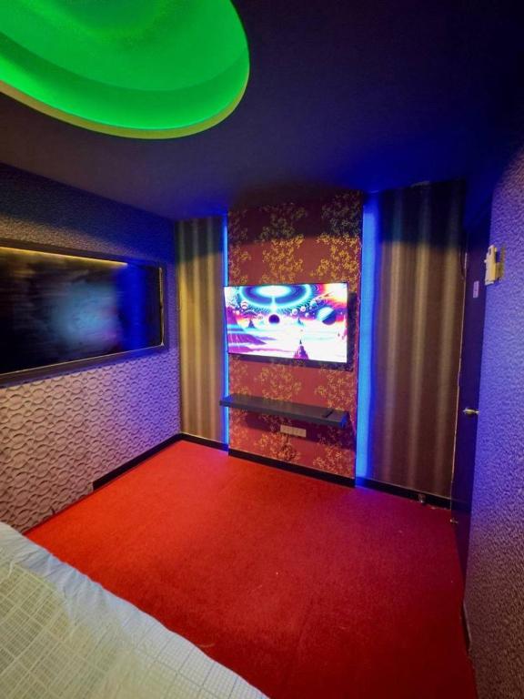 a room with a red carpet and a tv at Holy Hostel Sukhumvit 22 in Bangkok