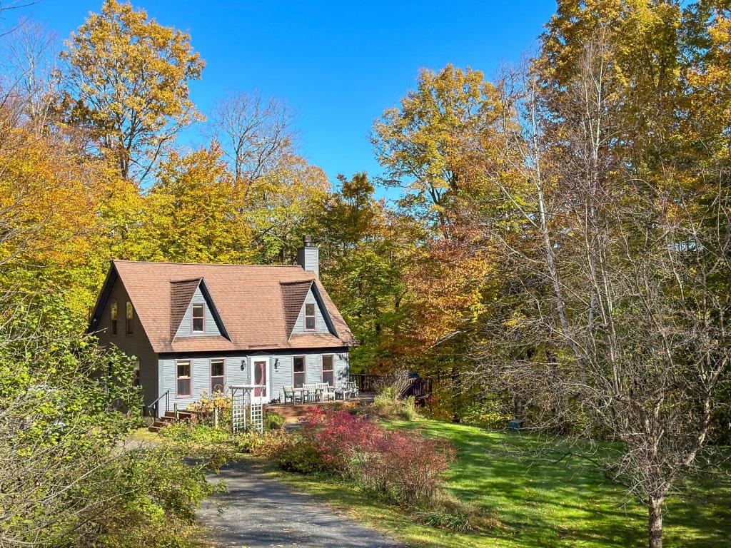 a white house in the middle of the woods at Shady Lane Retreat in Waitsfield