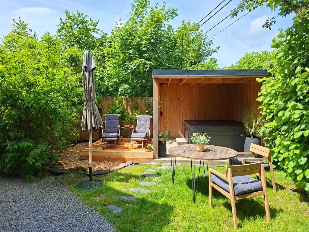 a patio with an umbrella and a table and chairs at La Cachette de Simone in Spa
