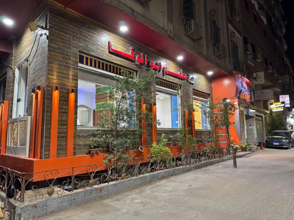 a restaurant with plants in the windows of a building at Hotel G in Sūhāj