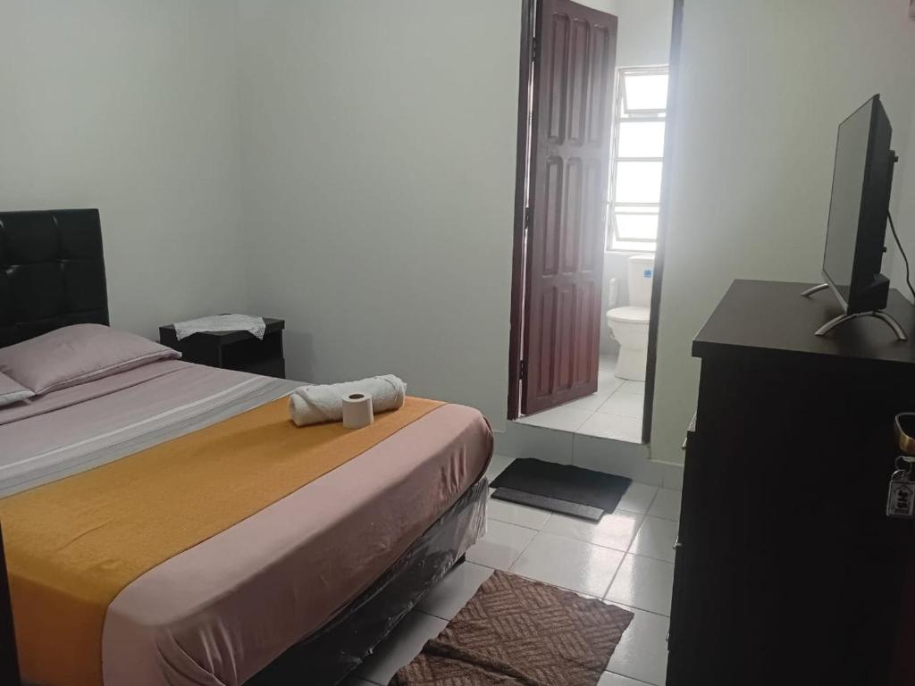 a bedroom with a bed and a flat screen tv at Hostal Center A in Santa Cruz de la Sierra