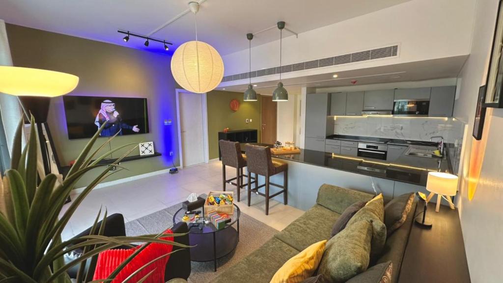 a living room with a couch and a kitchen at Century Stay by Bait Zain in As Sīfah