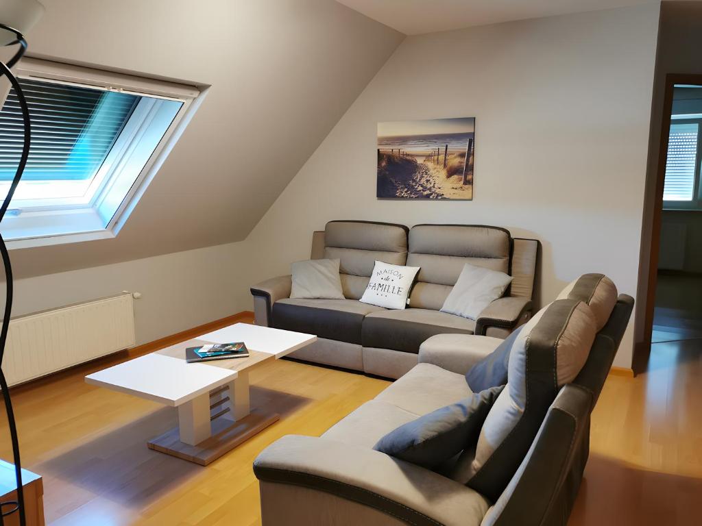 a living room with a couch and a table at Gîte De L'Oie Blanche in Blodelsheim
