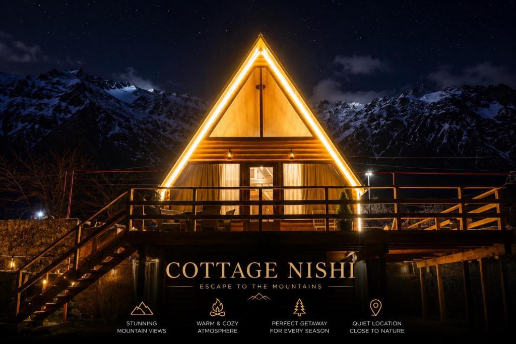 a log cabin with a sign that reads confidence risk service to the mountains at Cottage Nishi in Kazbegi