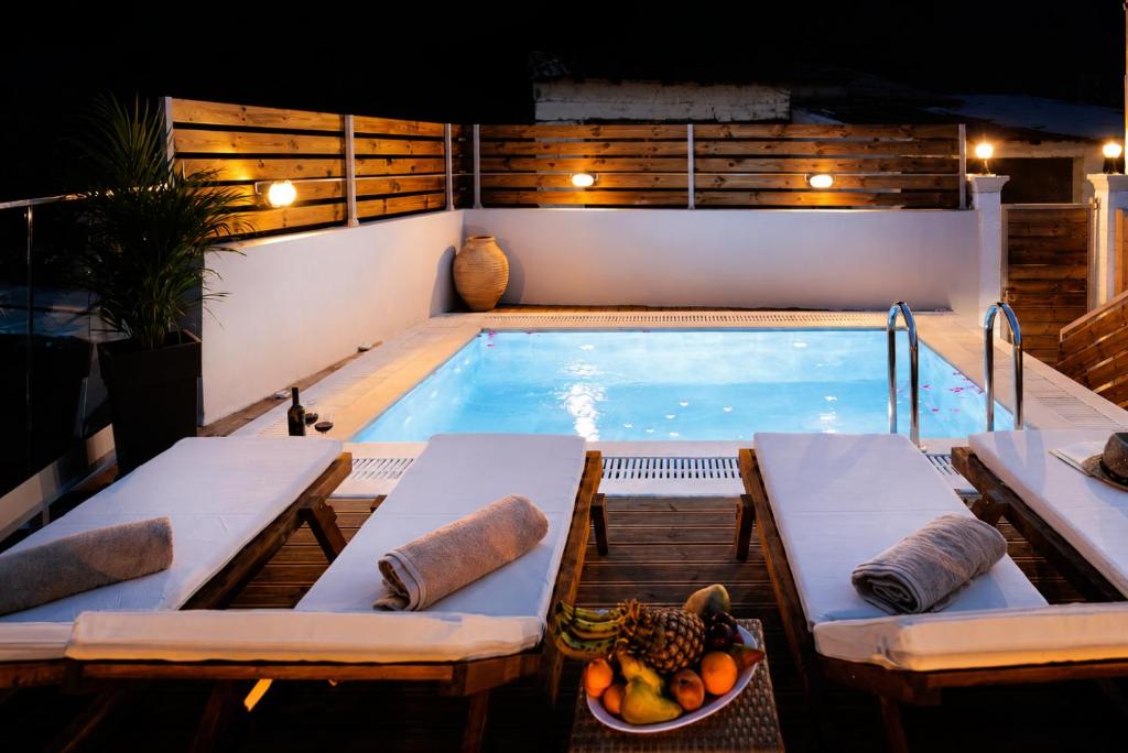 a pool with a table and a bowl of fruit next to it at Pavlos & Sofia Villa Vigla - Heated Private Pool in Ágios Matthaíos