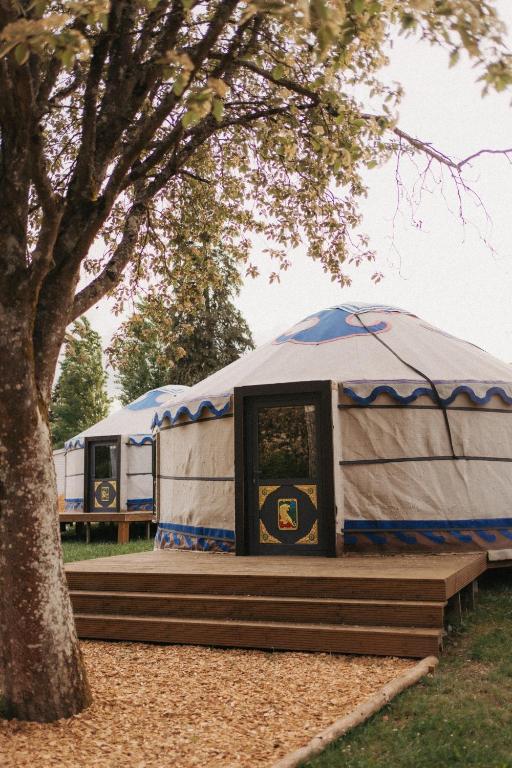 a blue and white yurt in a park with a tree at Yurt Mongolia - Camp La Belle Vie in Berdorf