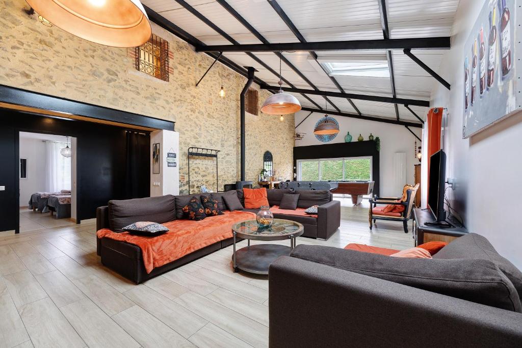 a living room with a couch and a table at Gîte La Ferme Du Mesnil in Sevremont