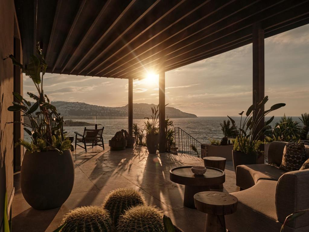 a patio with a view of the ocean at sunset at OKU Bodrum in Golturkbuku