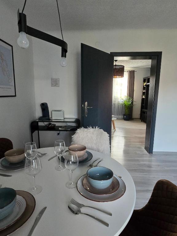 a table with plates and wine glasses on it at Ferienwohnung Monteurzimmer Mariens1 in Eppelborn