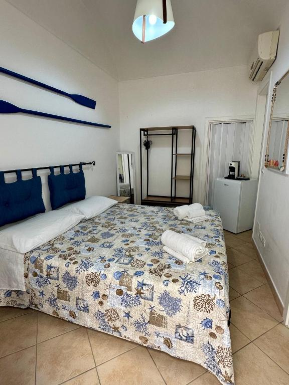a bedroom with a bed with a blue and white quilt at Cabina Da Mare in Marettimo