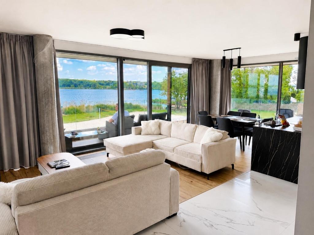 a living room with couches and a view of the water at Zegrze Riva with the view in Zegrze Południowe