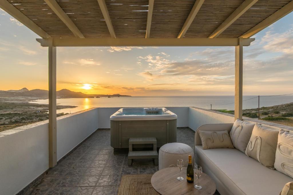 a living room with a couch and a tub on a balcony at Iliovasilema Studios in Mytakas