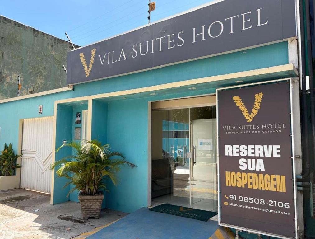 a building with a sign in front of a hotel at Vila Suítes in Barcarena