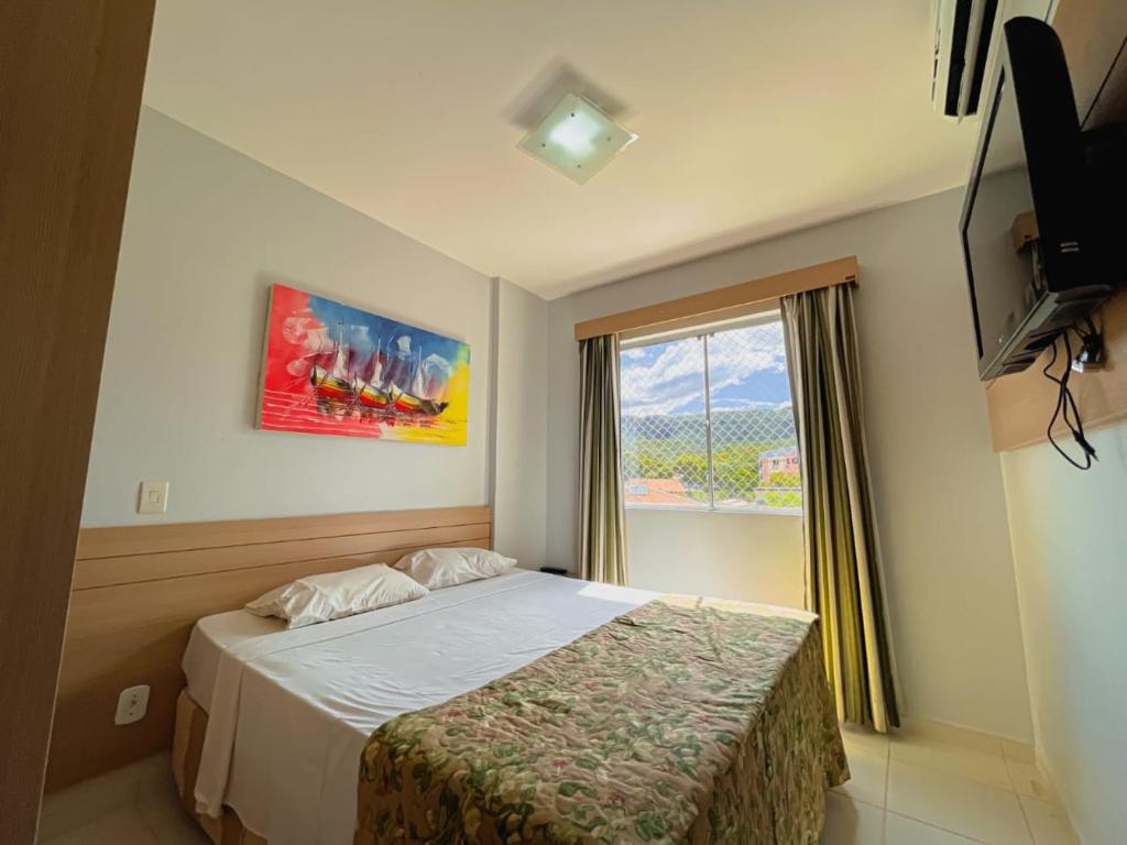 a hotel room with a bed and a window at Apartamento Veredas Flat - Rio Quente in Rio Quente