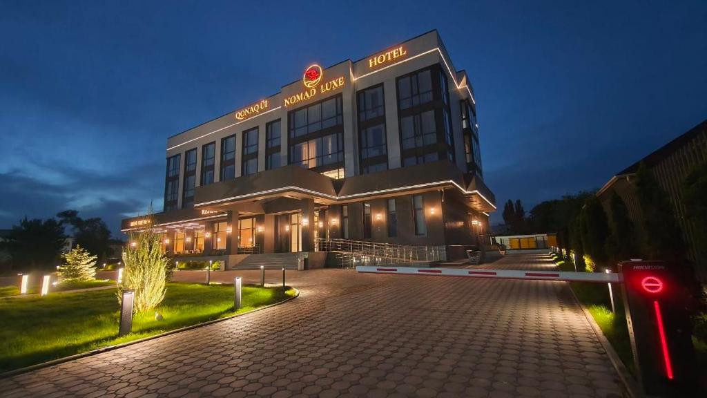 a large building with lights in front of it at NOMAD Luxe Hotel in Zharkent