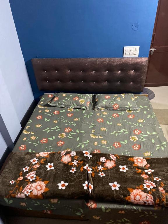 a bed with a green comforter with flowers on it at Friends corner Dharamshala in Dharmsāla