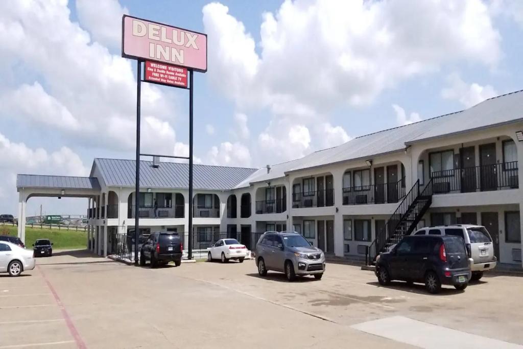 a drive in inn with cars parked in a parking lot at Delux Inn Mesquite Near I-30 Dallas in Mesquite