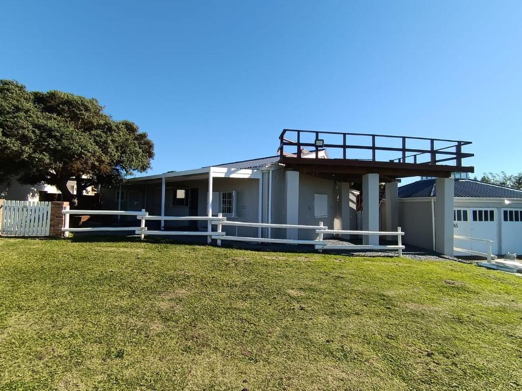 a house with a balcony on top of a yard at Kayser's Keep Self-Catering in Kayserʼs Beach